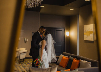 newly wed couple kissing in pre-function space at the Rewind Hotel