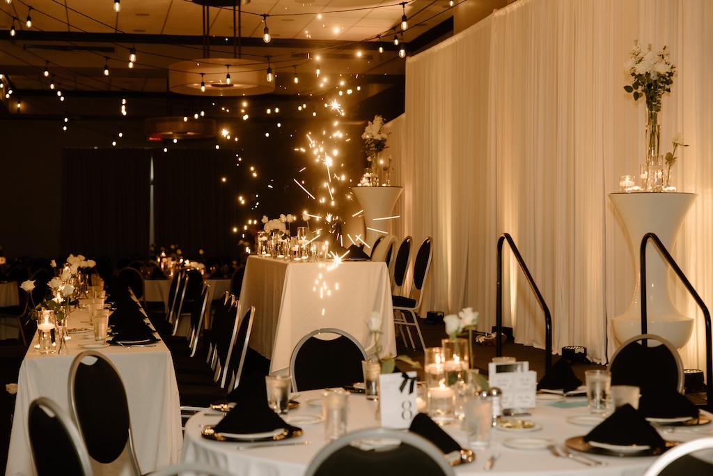 wedding tables and chairs set up with sparklers lighting up the room